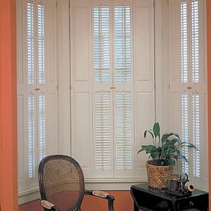 Installed single hung Brownstone shutters with raised panels and traditional louvered leafs Americana DeVenco Shutters